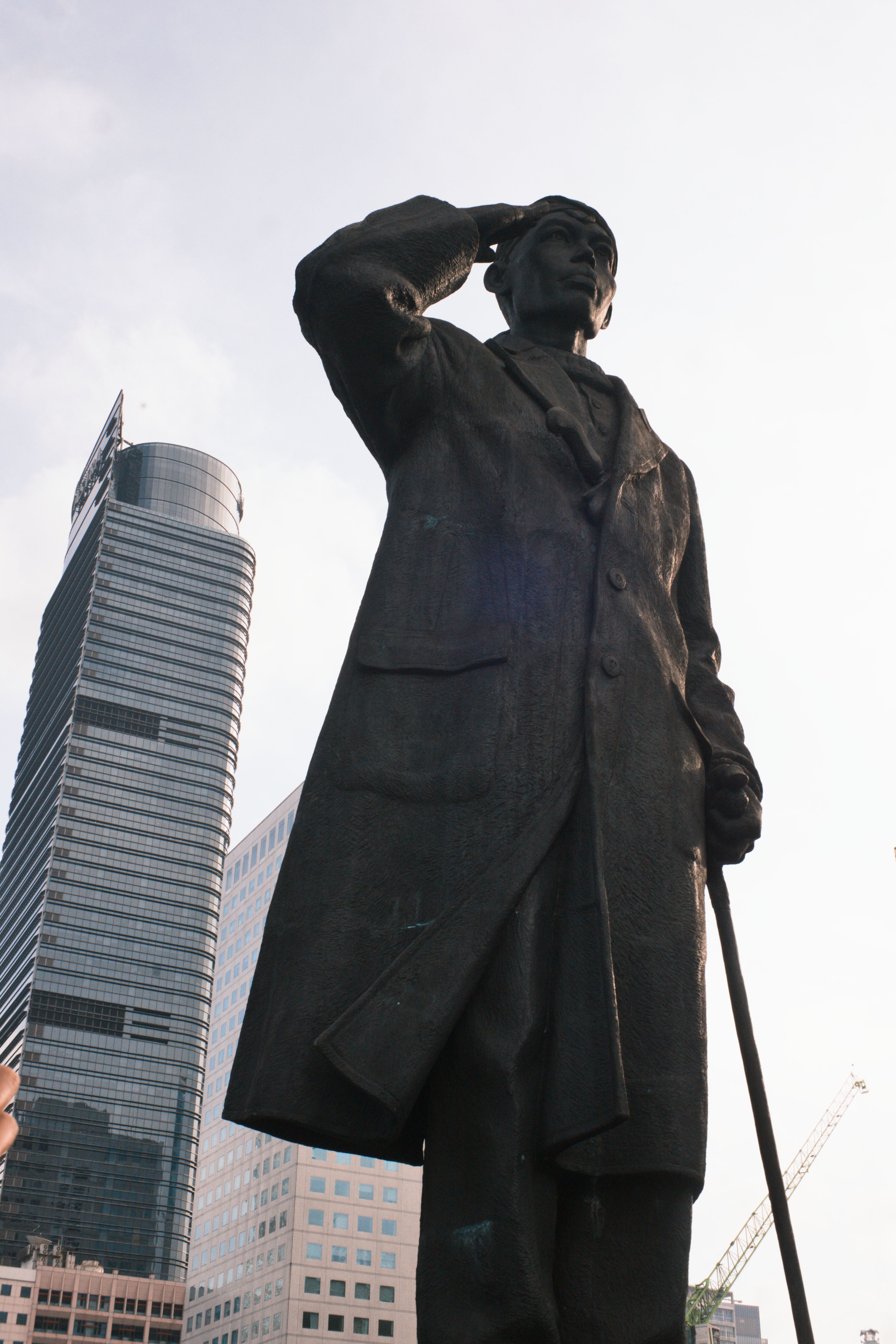 Bronze statue with skyscrapers in Jakarta, Indonesia's urban setting.