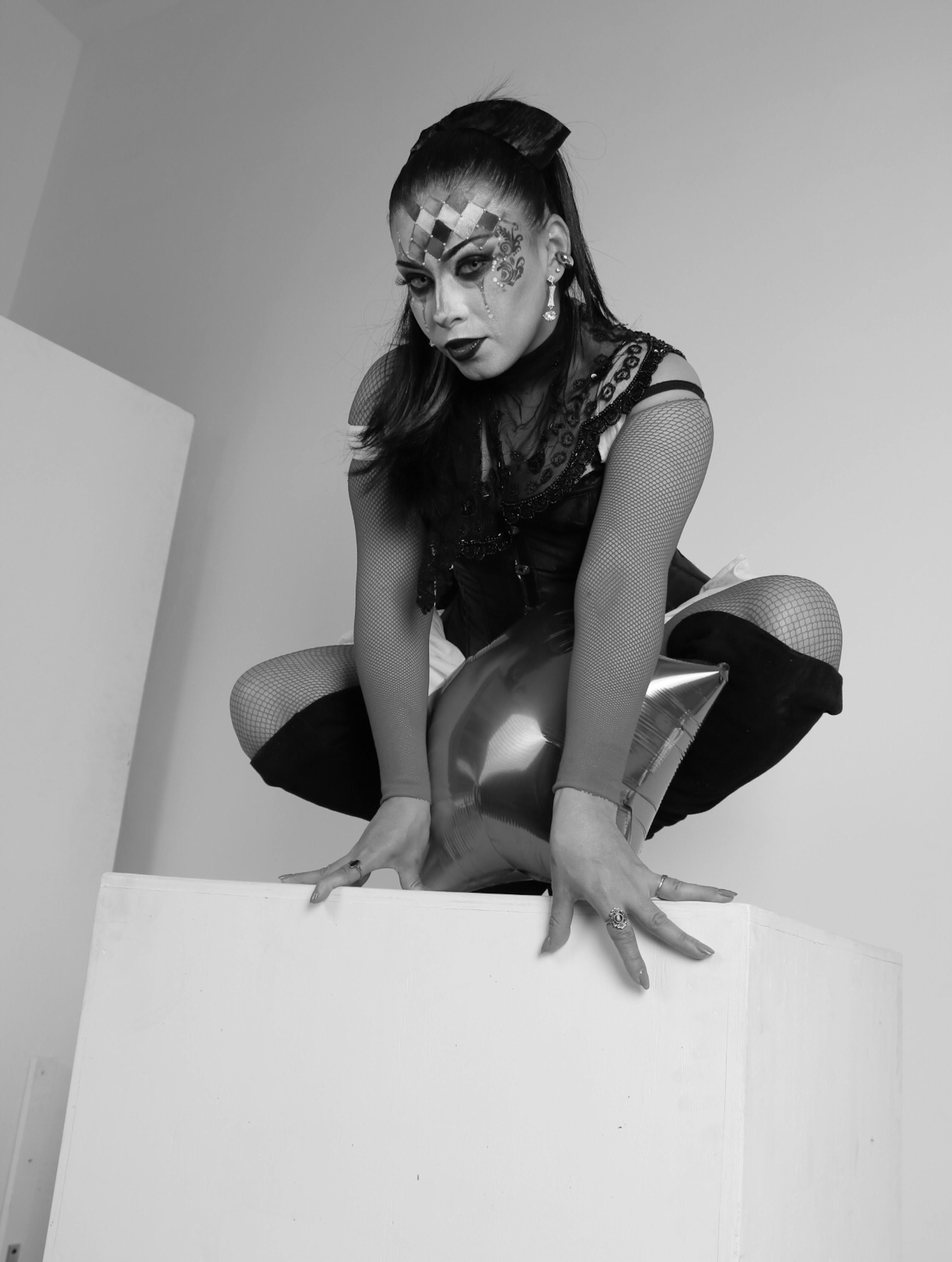 Gratis Foto hitam putih seorang penampil dengan kostum berpose dramatis di dalam ruangan. Foto Stok