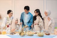 A group of young adults enjoying traditional Indonesian cuisine during a festive celebration indoors.