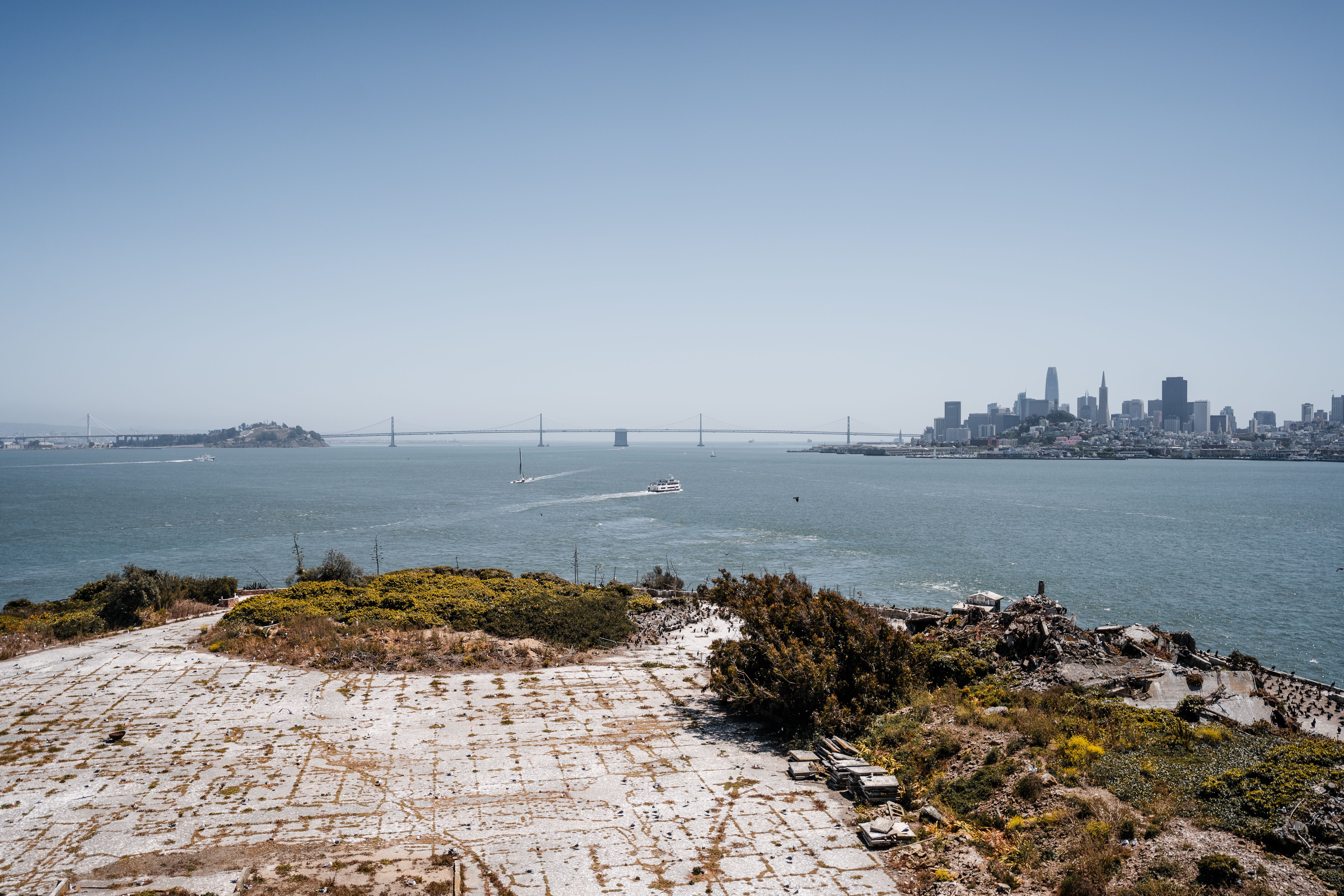 Alcatraz Island, with its historic prison buildings, stands starkly against the blue waters of San Francisco Bay.