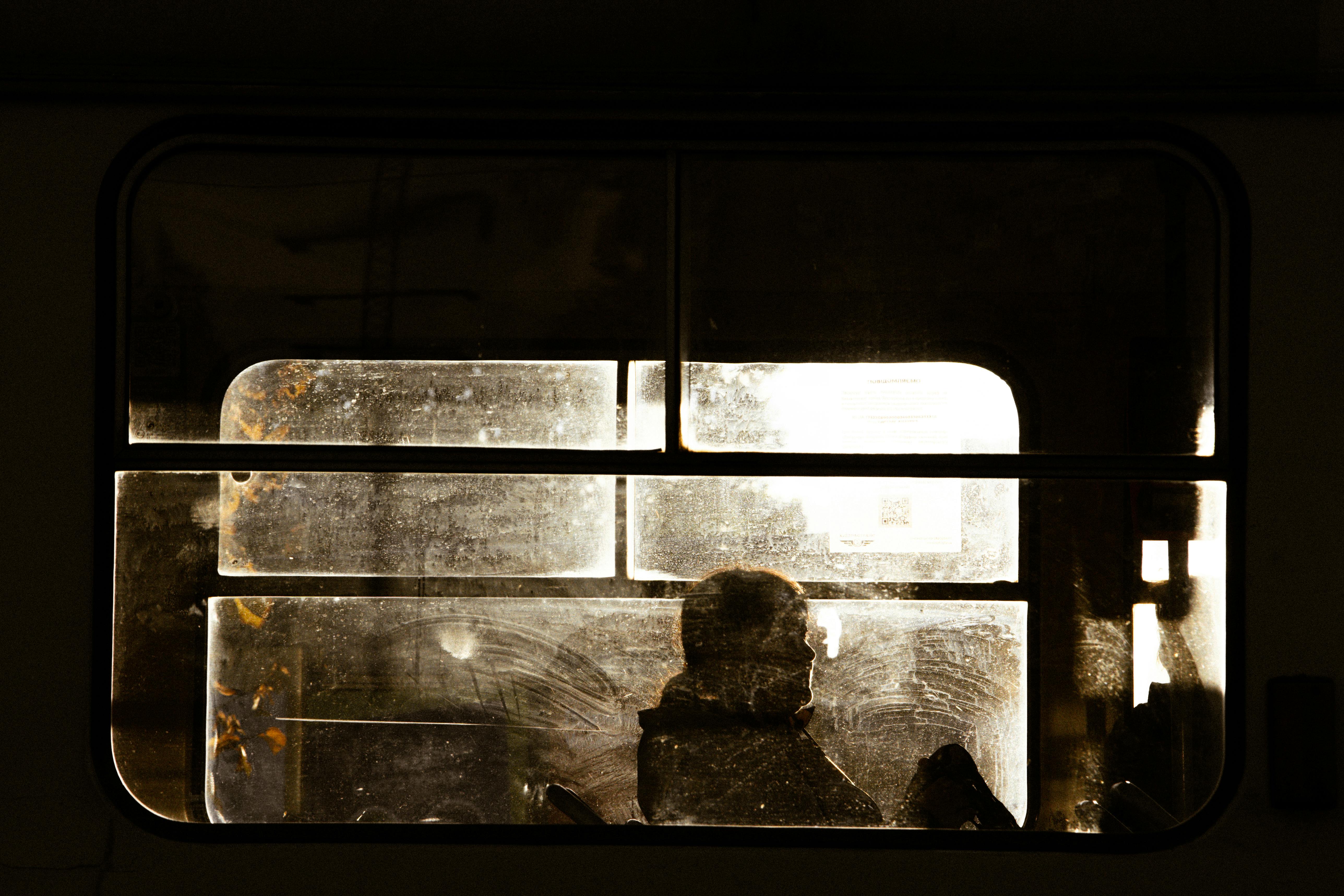 Free A moody silhouette of a person through a train window in Kyiv, Ukraine. Stock Photo