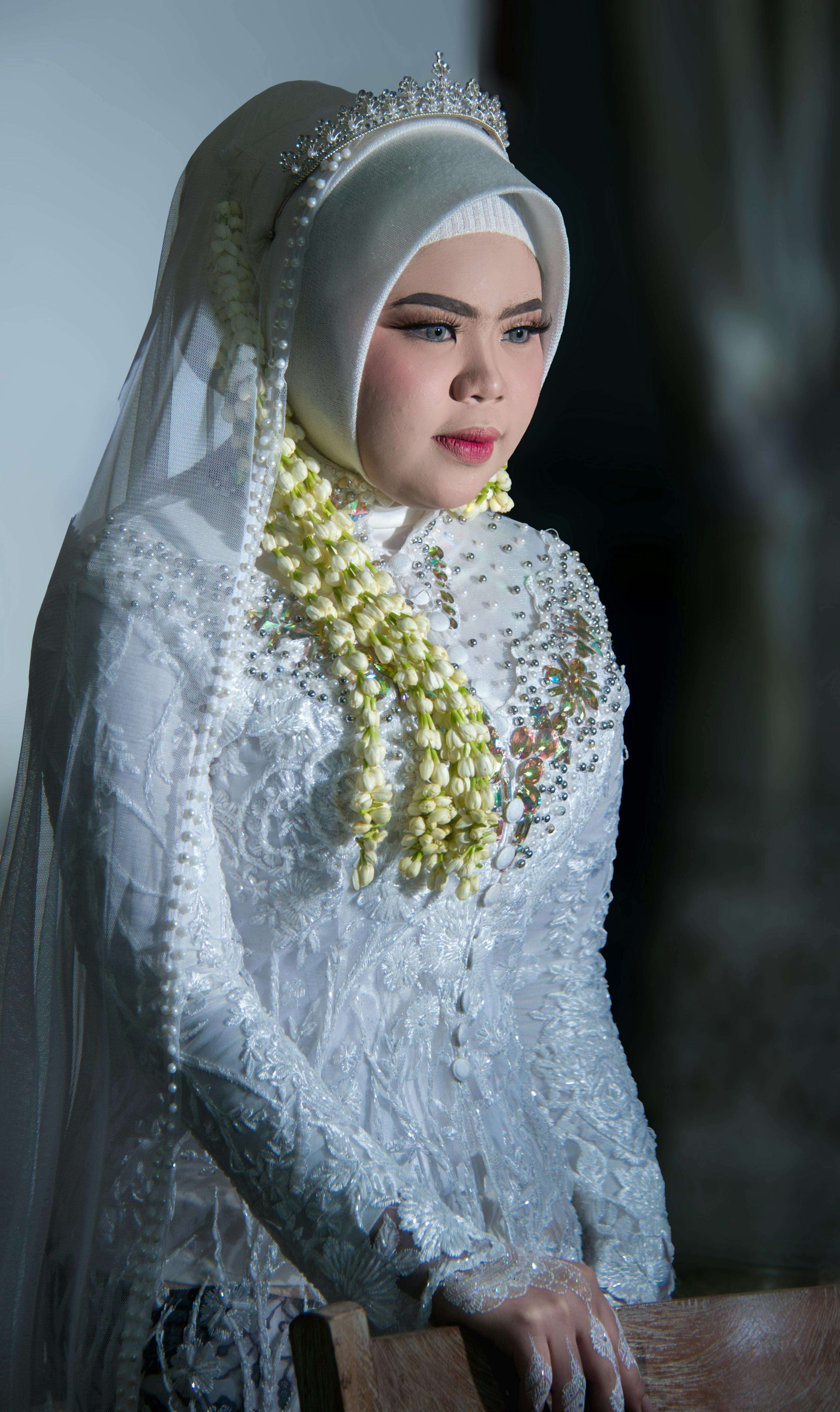 Beautiful Indonesian bride in a traditional wedding dress with elegant details during a Muslim ceremony in Banten, Indonesia.