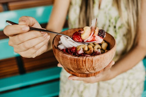 Free Person Holding Stainless Steel Spoon With Sliced Strawberries Stock Photo