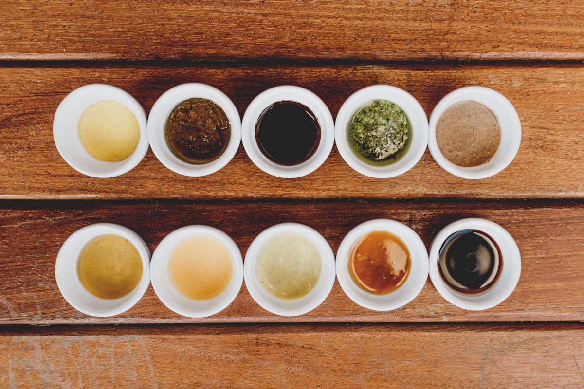 Assorted dipping sauces displayed in bowls on a rustic wooden table