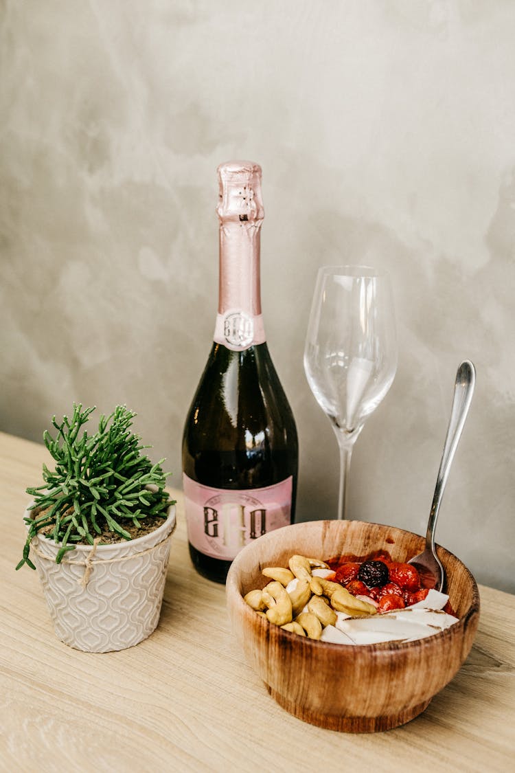 Wine Bottle Beside Wine Glass And Bowl Of Food