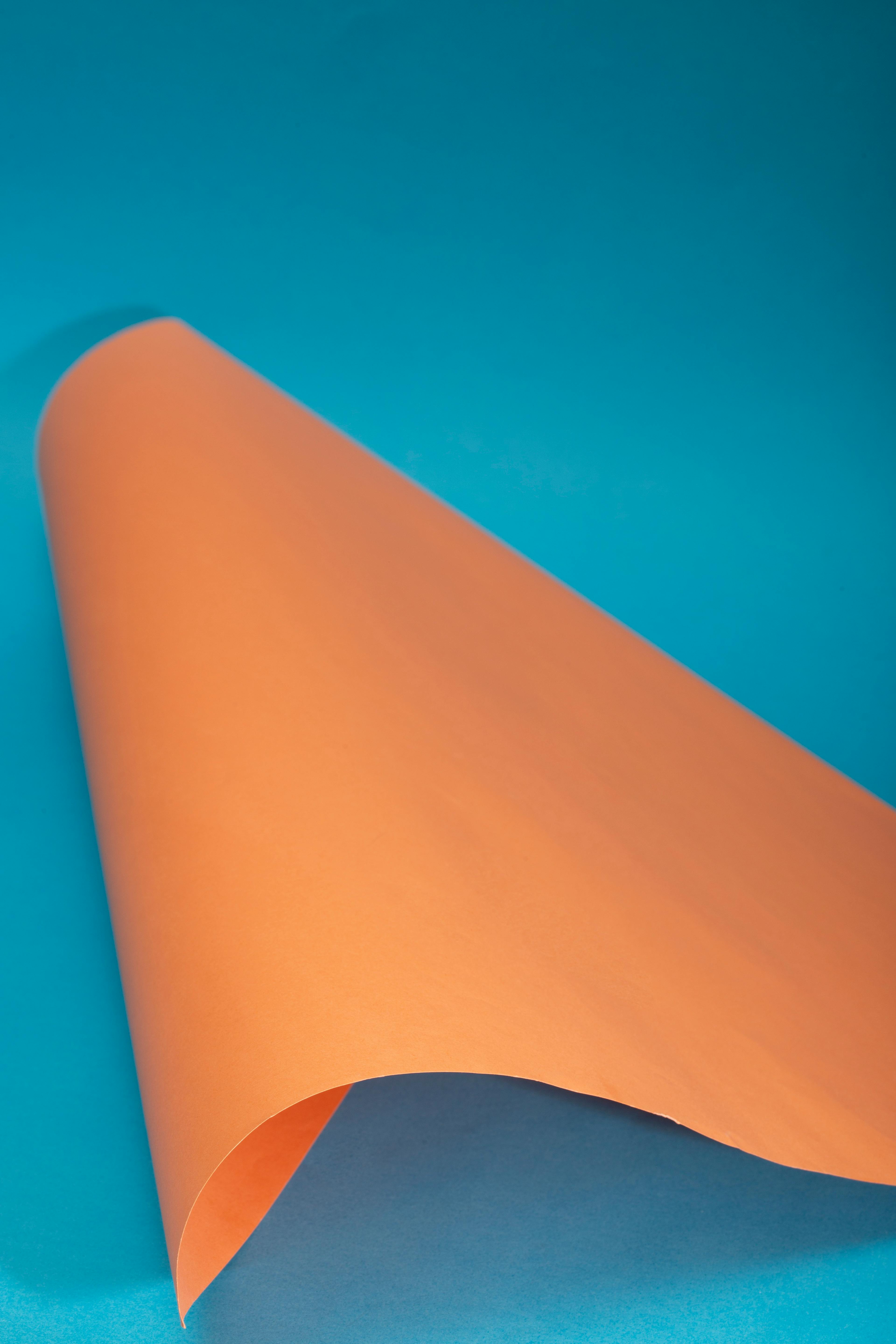 Kostenlos Lebendige abstrakte Komposition mit orangefarbenem Papier auf blauem Hintergrund, Studioaufbau. Stock-Foto