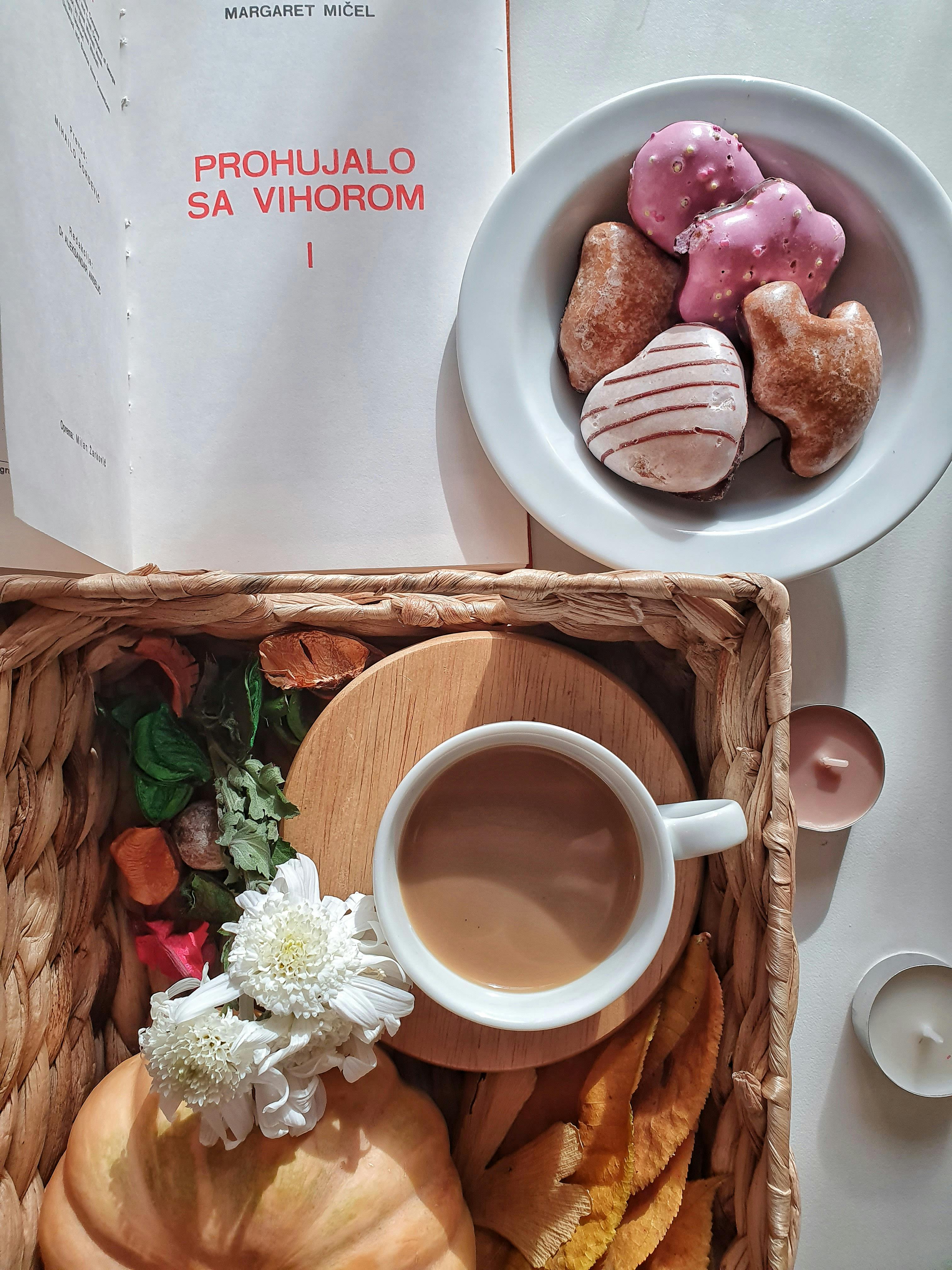 早餐设置温暖而诱人，包括咖啡、甜甜圈和鲜花