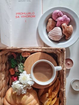 早餐设置温暖而诱人，包括咖啡、甜甜圈和鲜花