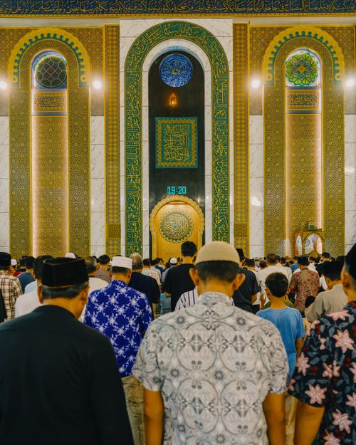 Free Muslim worshippers gathered for prayer inside a magnificently ornate mosque in Jawa Timur, Indonesia. Stock Photo