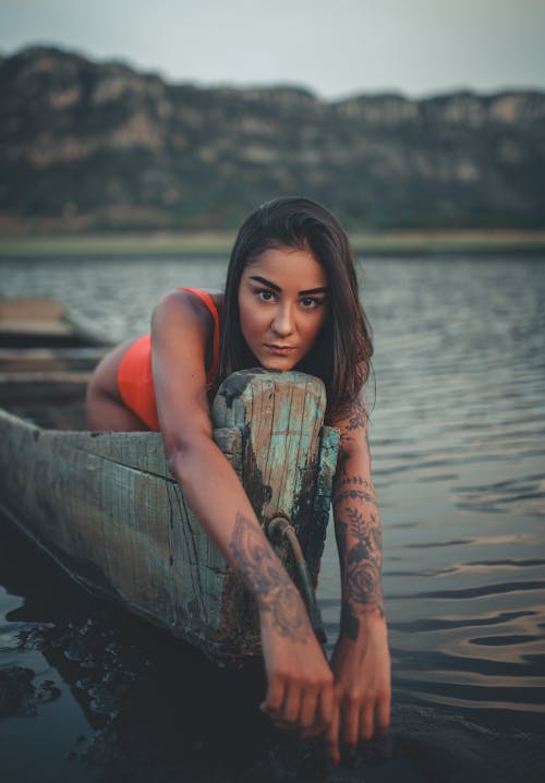 無料 木製のボートに乗った女性の浅い焦点写真 写真素材