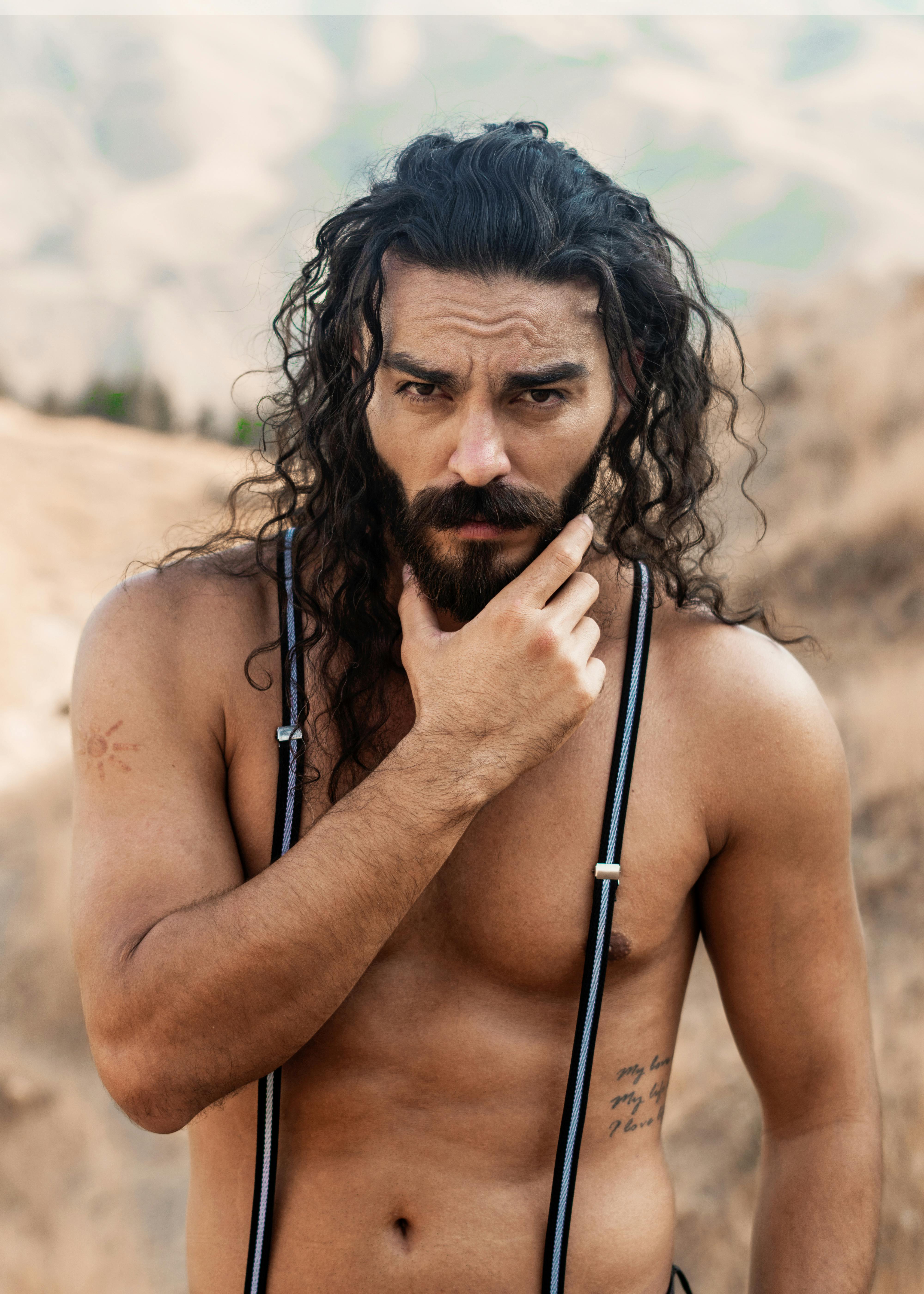 topless man with black hair and suspenders