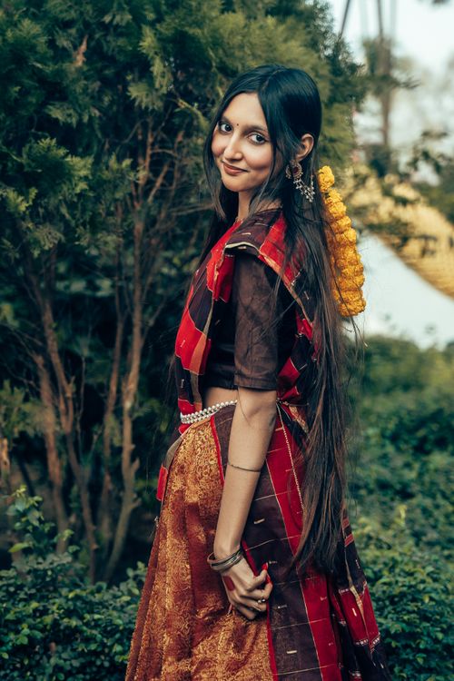 Free Portrait of a young woman in traditional South Asian attire, smiling outdoors. Stock Photo