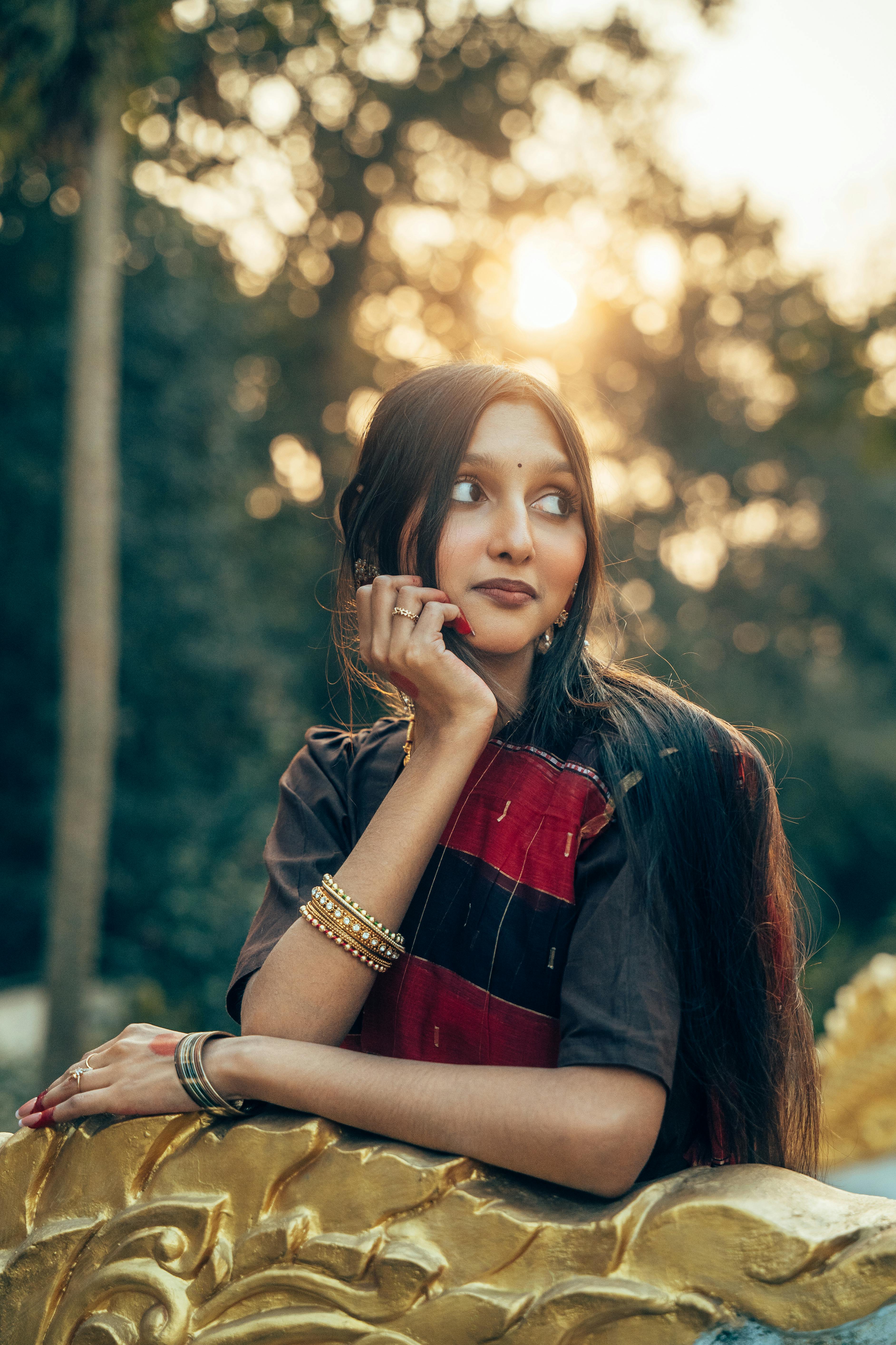 Ücretsiz Bangladeş'in Cumilla kentinde, gün batımında kırmızı bir sari giymiş genç bir kadın zarif bir şekilde poz veriyor. Stok Fotoğraflar