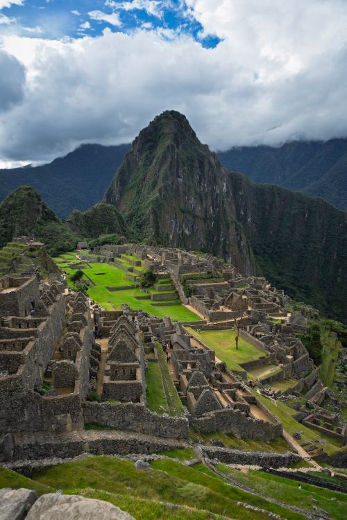 Free A breathtaking view of the ancient Incan city Machu Picchu surrounded by lush mountains. Stock Photo