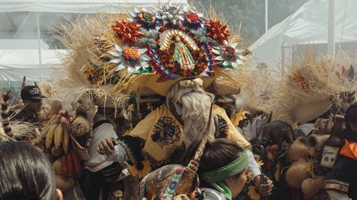 Free Colorful display of Mexican culture featuring traditional masks and costumes at a lively carnival. Stock Photo