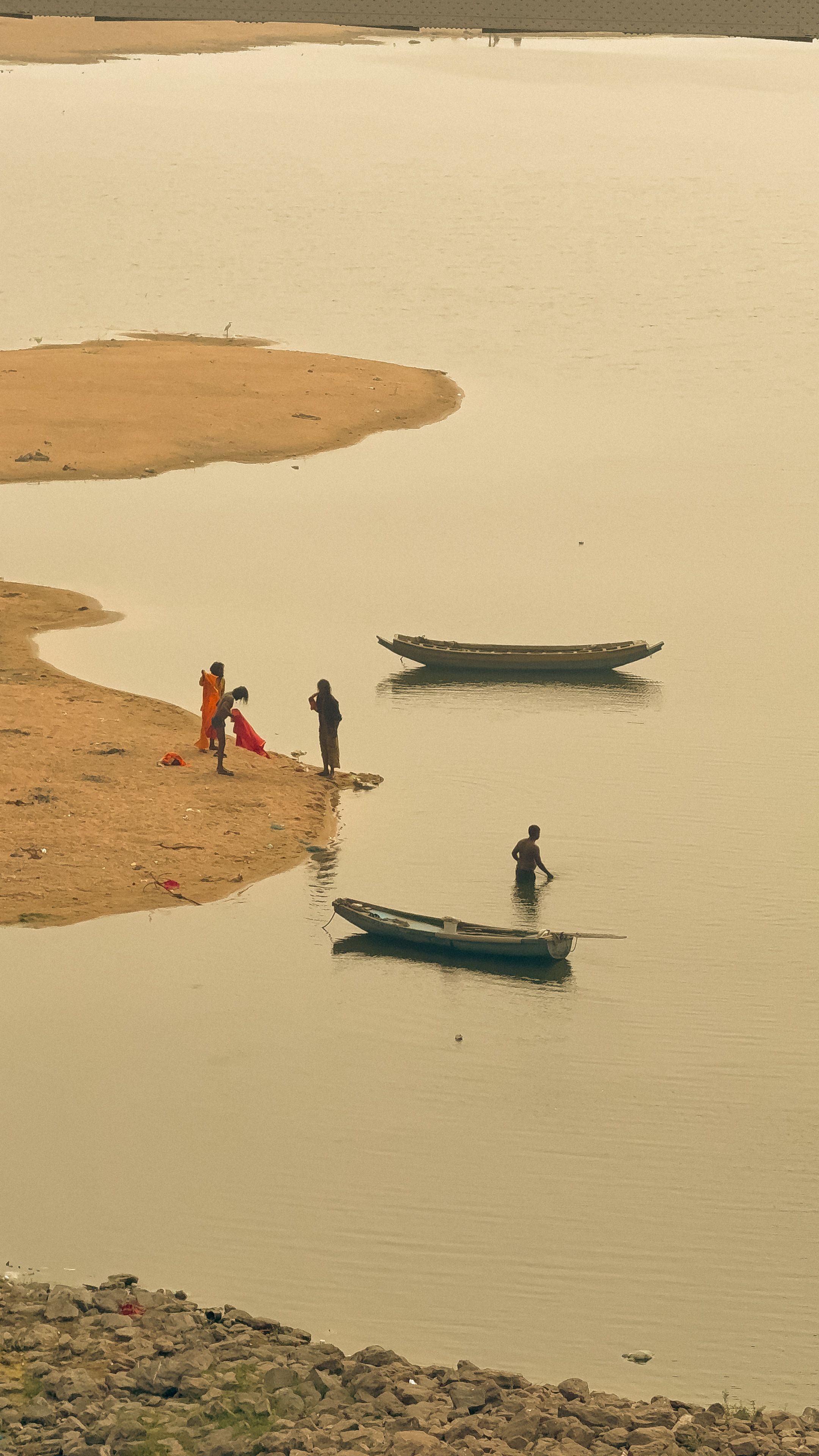 Fishermen working by the banks of the Krishna River in Vijayawada, India at sunset.