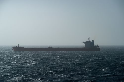 Free A large cargo ship sails on the choppy ocean waters under a hazy sky, creating a serene maritime scene. Stock Photo