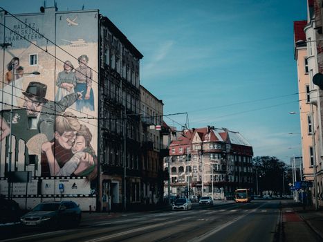 European city street scene with a prominent wall mural, capturing urban architecture.