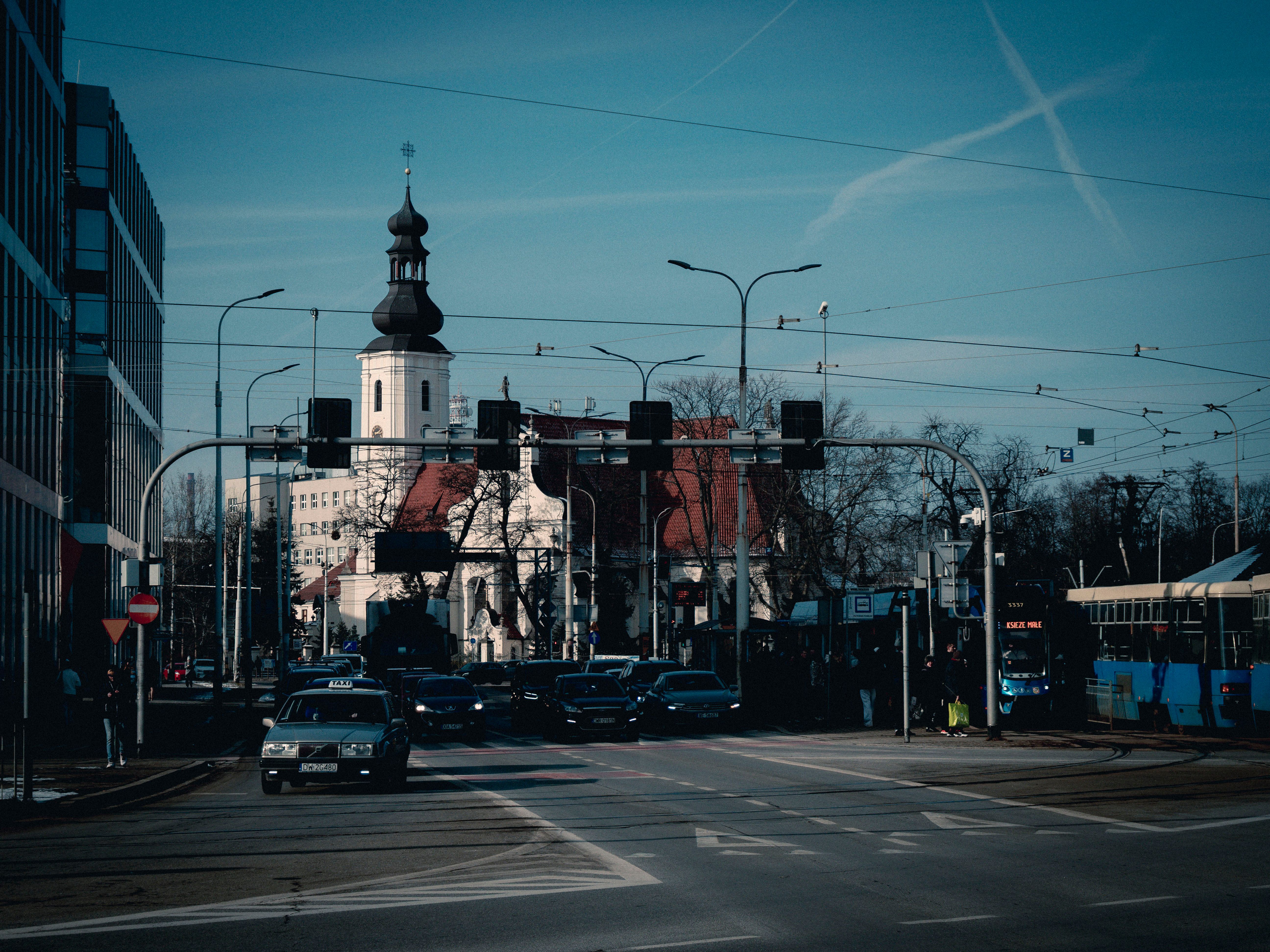 Blue tram 20 crossing tracks on Graf Ignatiev Street with the Sedmochislenitsi church behind