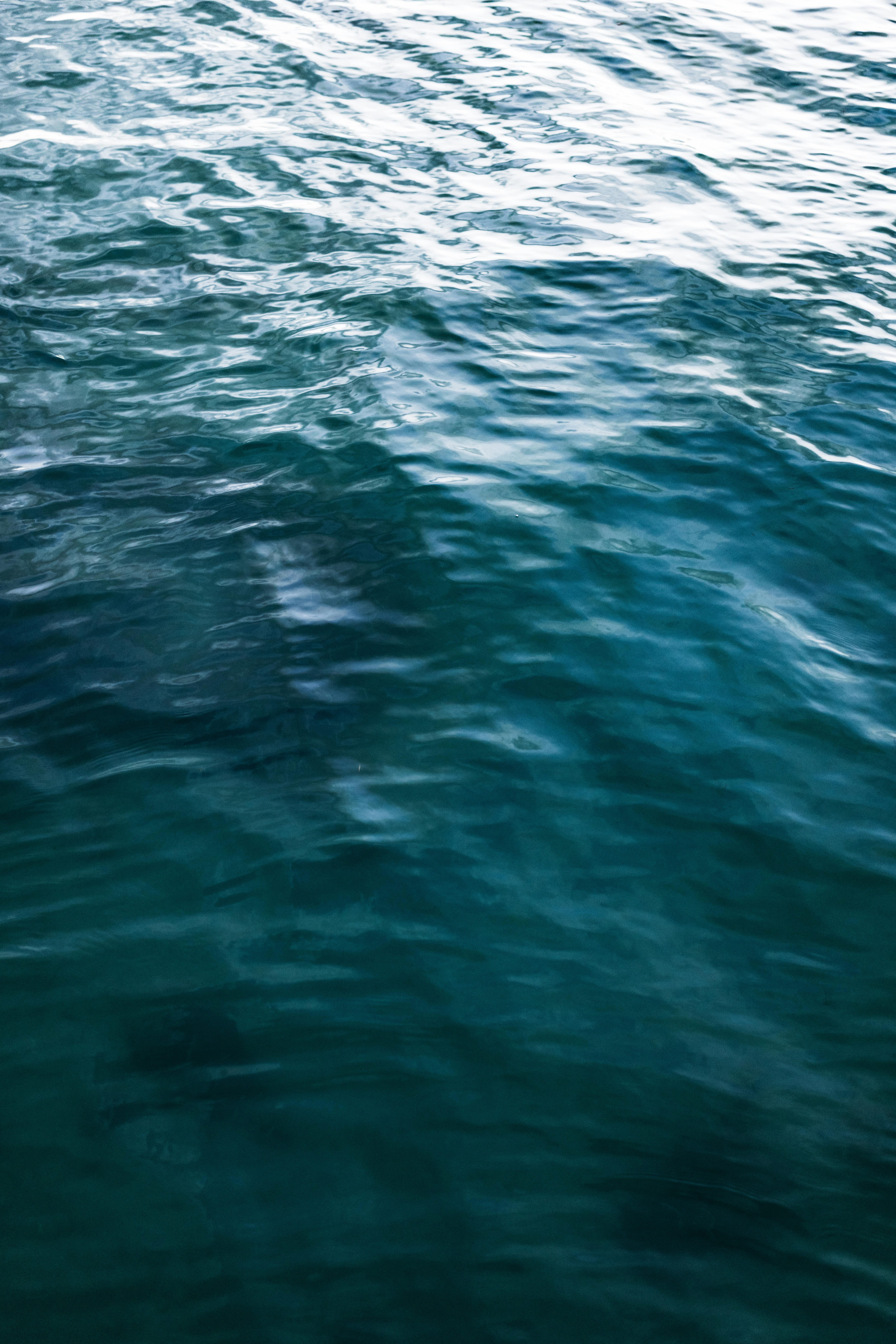 Ücretsiz Hafif dalgalanmaları ve canlı mavisiyle okyanus suyunun sakin bir manzarası. Arka plan için ideal. Stok Fotoğraflar