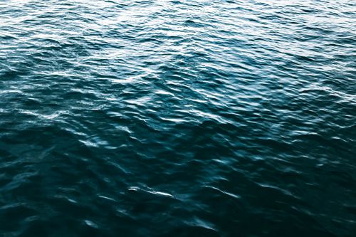 Free A dynamic capture of ocean water showing vivid textures and rich blue hues under daylight. Stock Photo