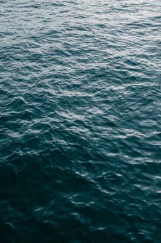 Calm ocean water surface showing gentle ripples and texture under daylight.
