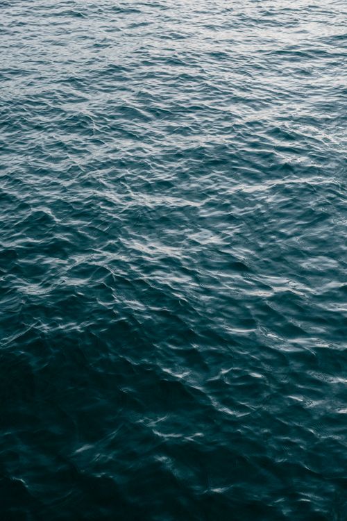 Free Calm ocean water surface showing gentle ripples and texture under daylight. Stock Photo