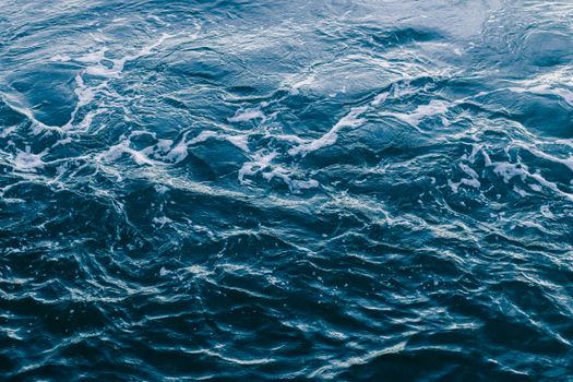 Captivating view of ocean waves creating a textured and dynamic water surface with white foam patterns.