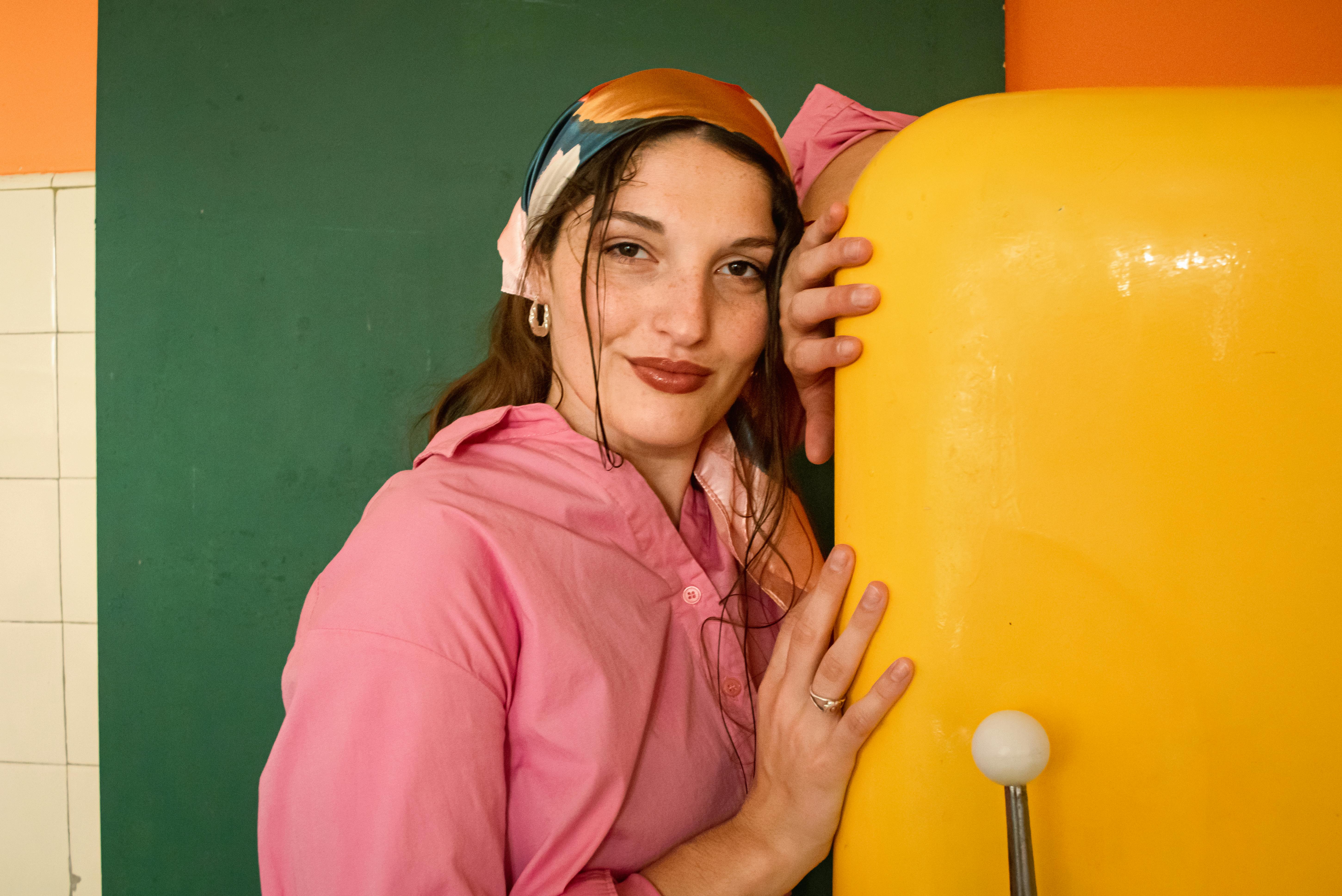 Gratis Ritratto di una donna sorridente in una cucina vivace dall'atmosfera retrò. Foto a disposizione