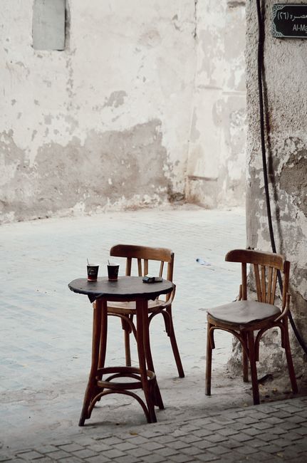 Cozy outdoor cafe setting with empty chairs in Jeddah, Saudi Arabia's historic district.