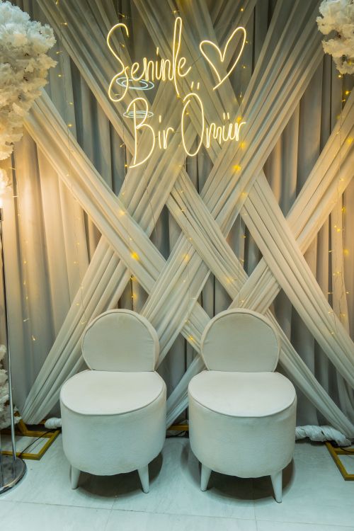 Free Romantic wedding backdrop with elegant chairs and floral decor, featuring 'Seninle Bir Ömür' inscription. Stock Photo