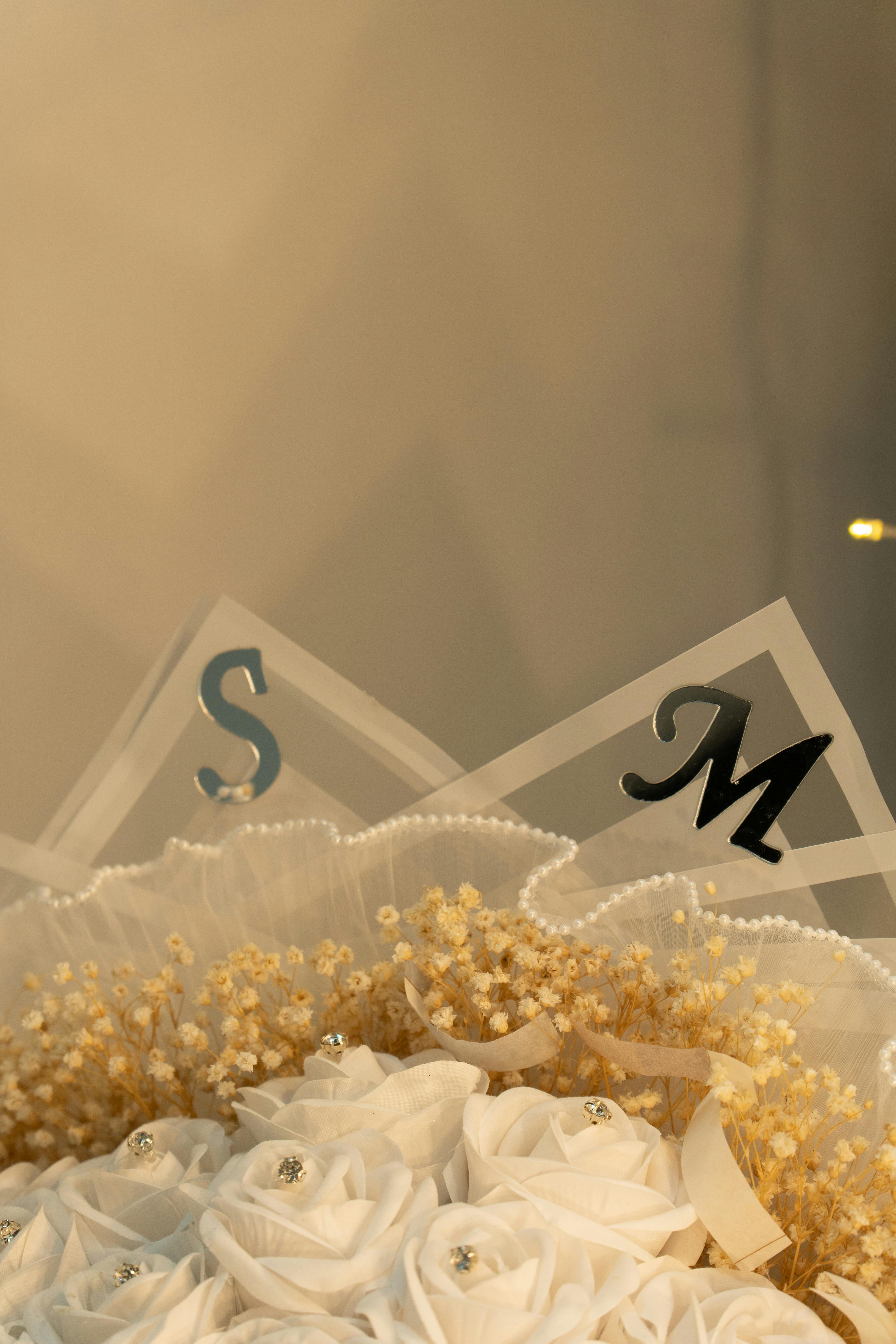 Gratis Vakker hvit rosebukett utsmykket med gulldetaljer og initialene S og M. Arkivbilde