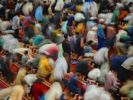 Dynamic scene of prayers during Ramadan in a Jakarta mosque, with vivid movement.