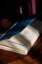 Open Book with Blue Cover on Wooden Table