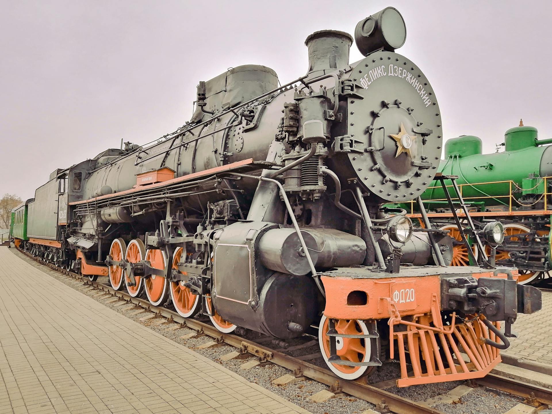 Close-up of a vintage steam locomotive parked on railway tracks outdoors.