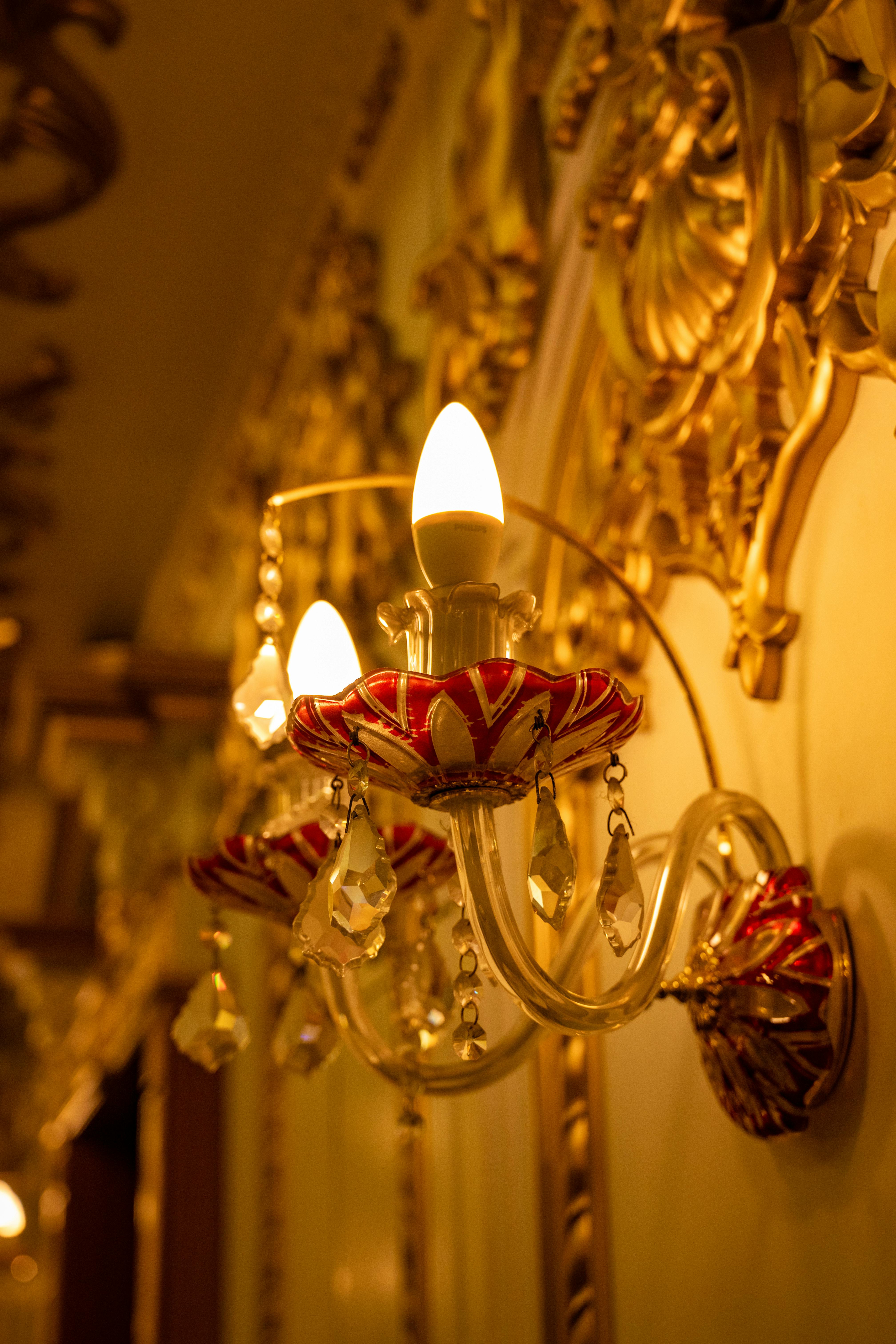 Gratis Lampu dinding vintage elegan dengan hiasan kristal dan pencahayaan hangat dalam suasana mewah. Foto Stok