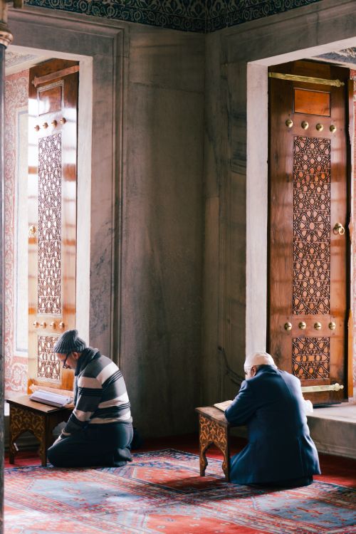Free Two men engrossed in prayer in a beautifully decorated mosque in Istanbul, Türkiye. Stock Photo