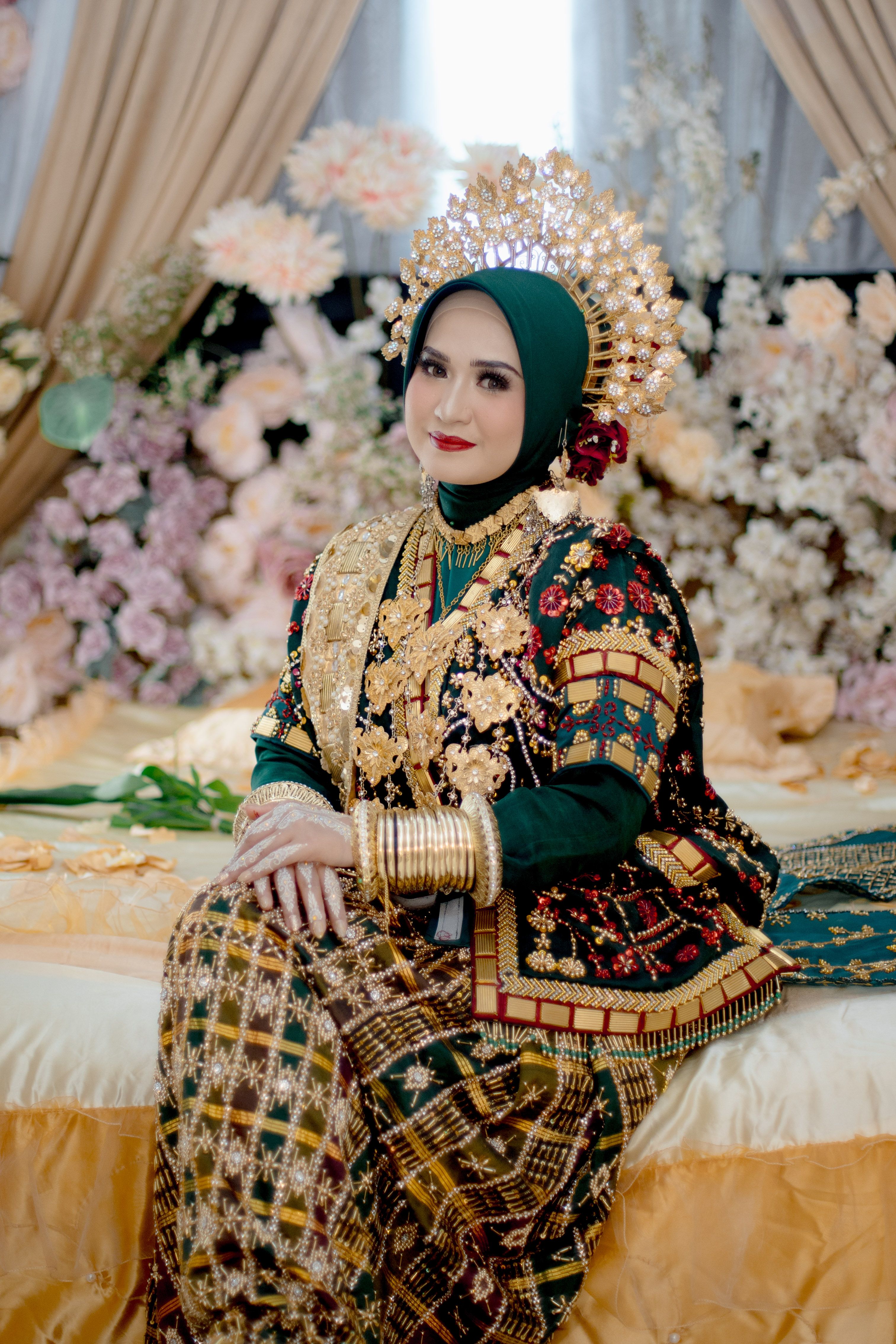 A bride in traditional Bugis attire with elegant gold accessories, Kendari, Indonesia.