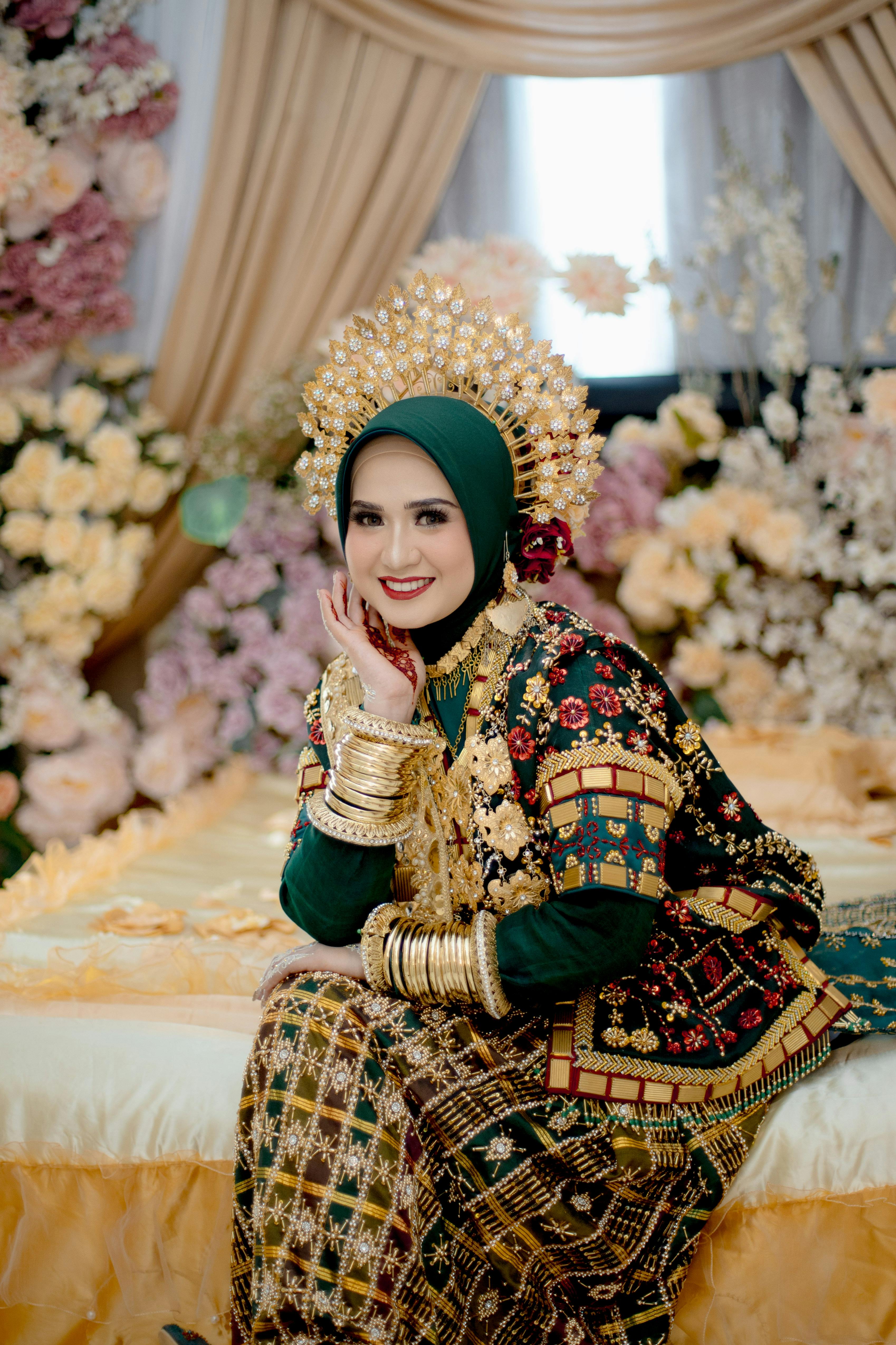 Portrait of a bride in traditional Bugis attire with intricate gold headwear in Kendari, Indonesia.