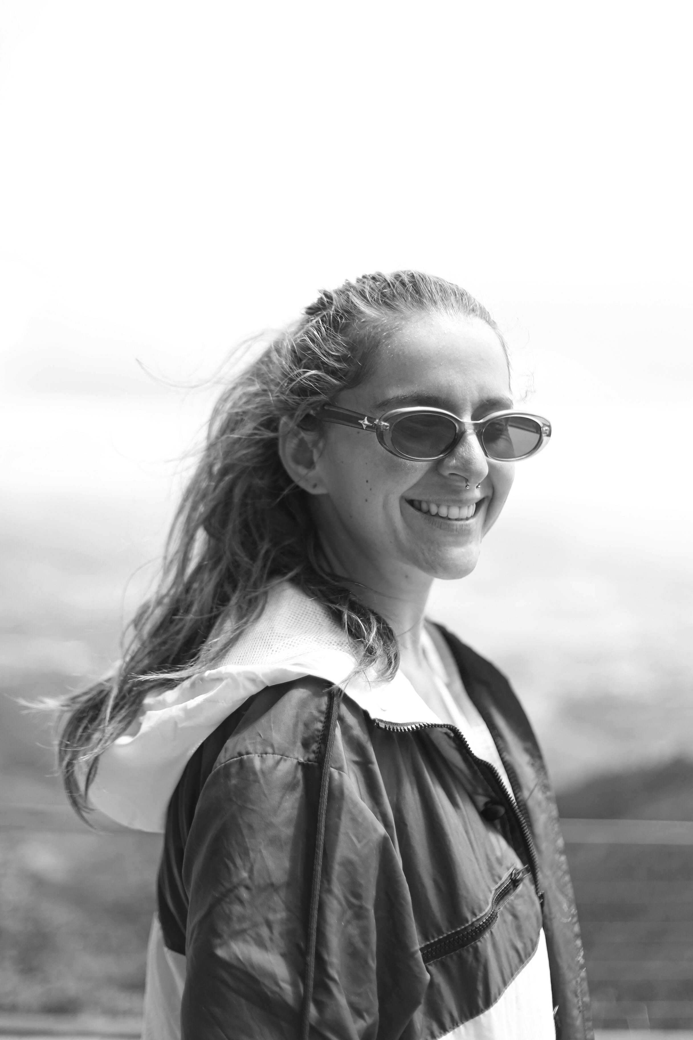 Free Portrait of a young woman smiling outdoors, captured in black and white in Minas Gerais, Brazil. Stock Photo