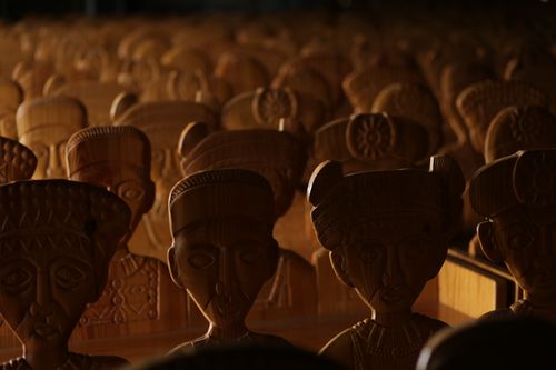 Free Artistic display of carved wooden figures, showcasing detailed craftsmanship under soft ambient lighting. Stock Photo