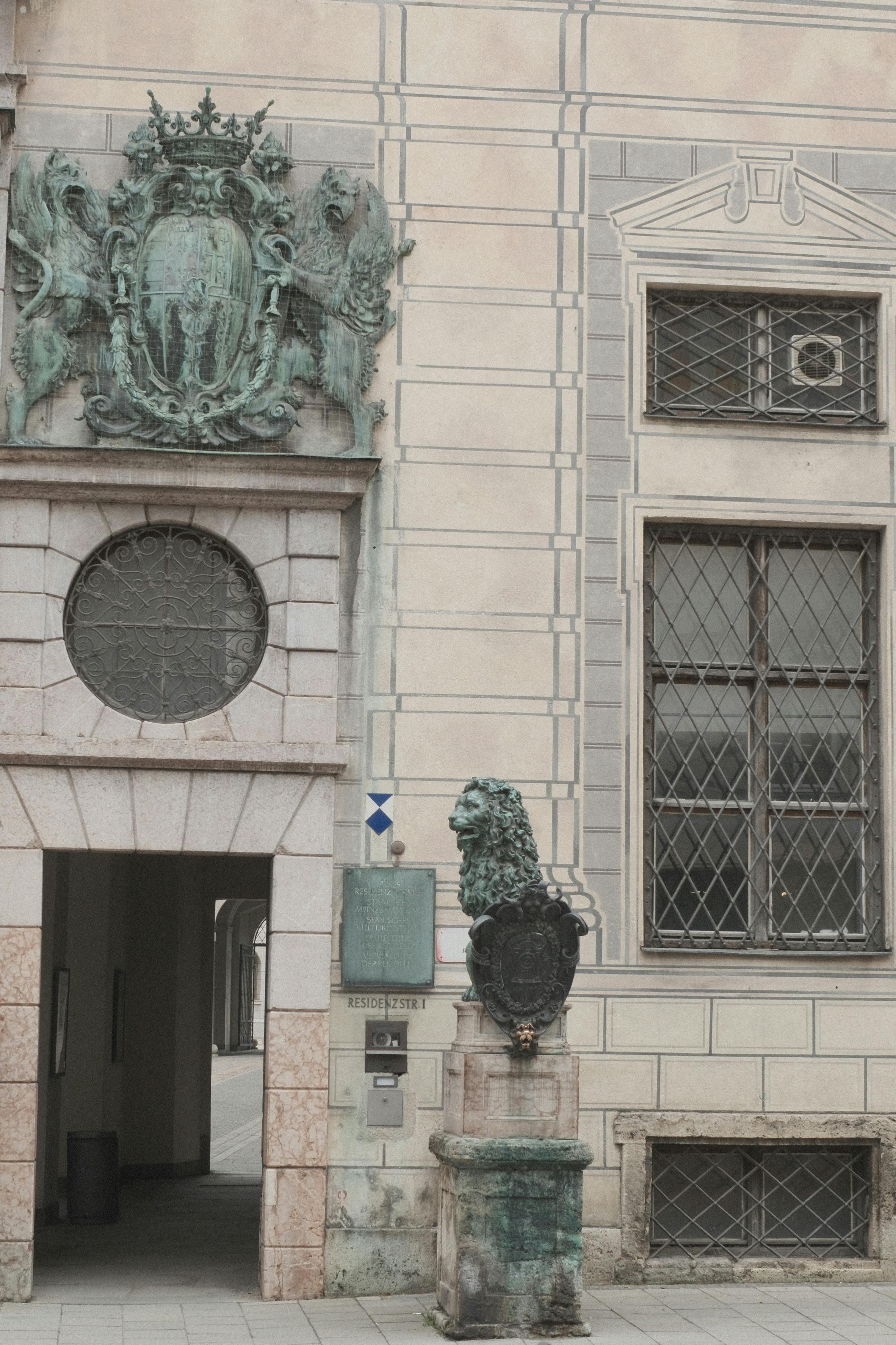 無料 ドイツのミュンヘンにあるブロンズのライオンの彫刻が特徴的な優雅な建築ファサード。 写真素材