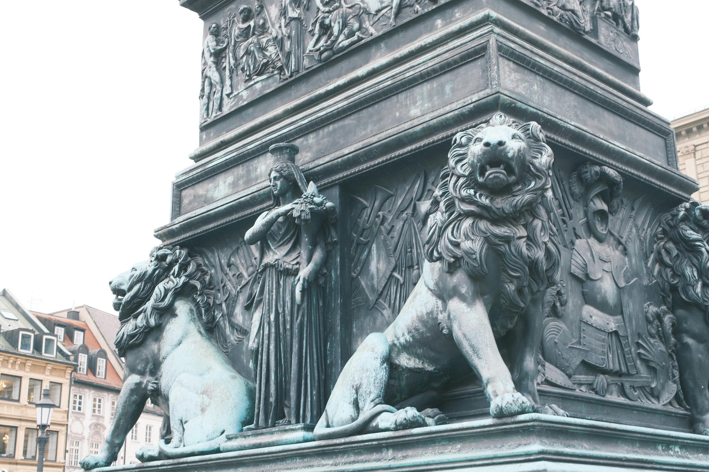 Gratis Intrikate steinskulpturer med løver og figurer i München, Tysklands arkitektoniske landskap. Arkivbilde