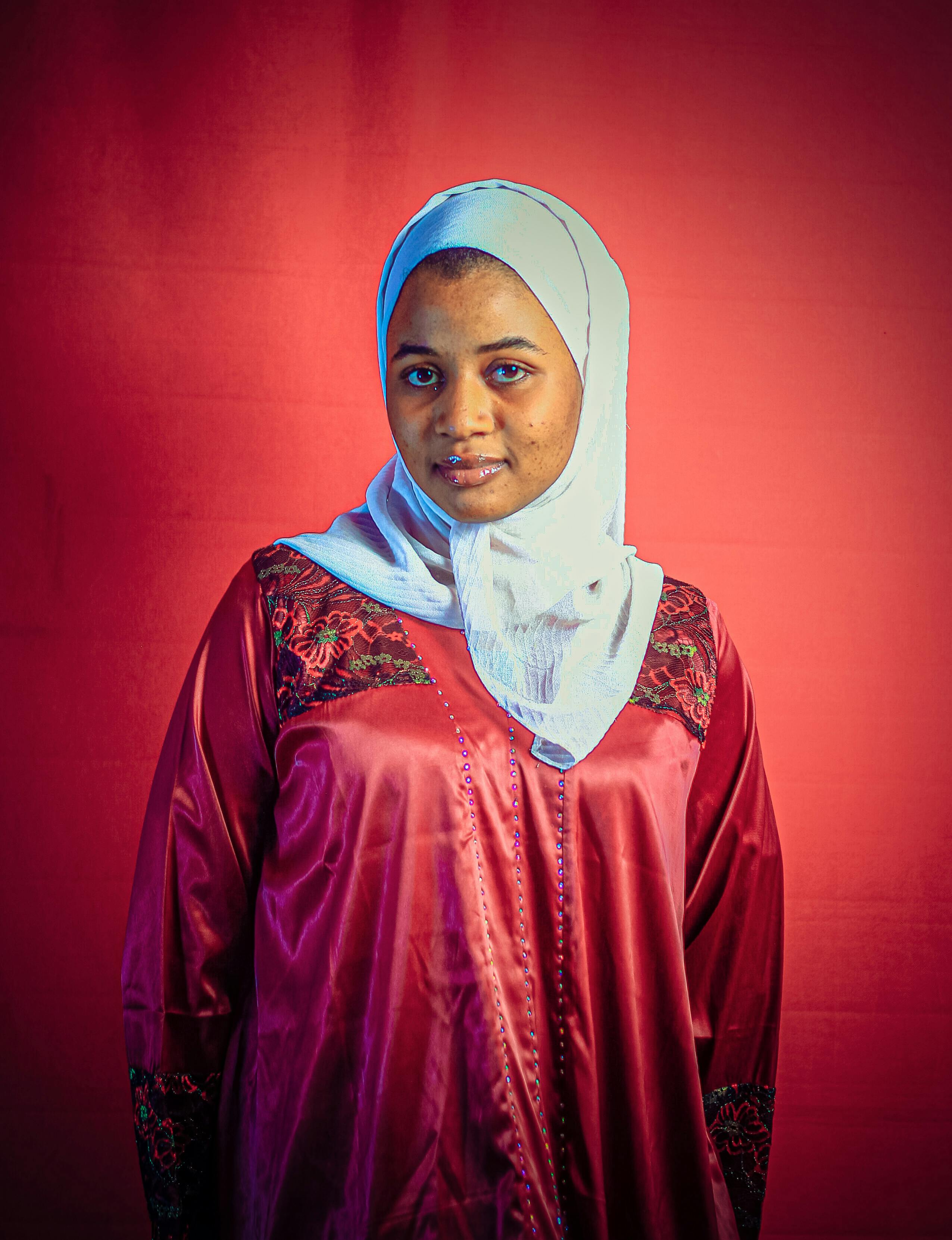 Captivating portrait of a woman in traditional attire against a vibrant background.
