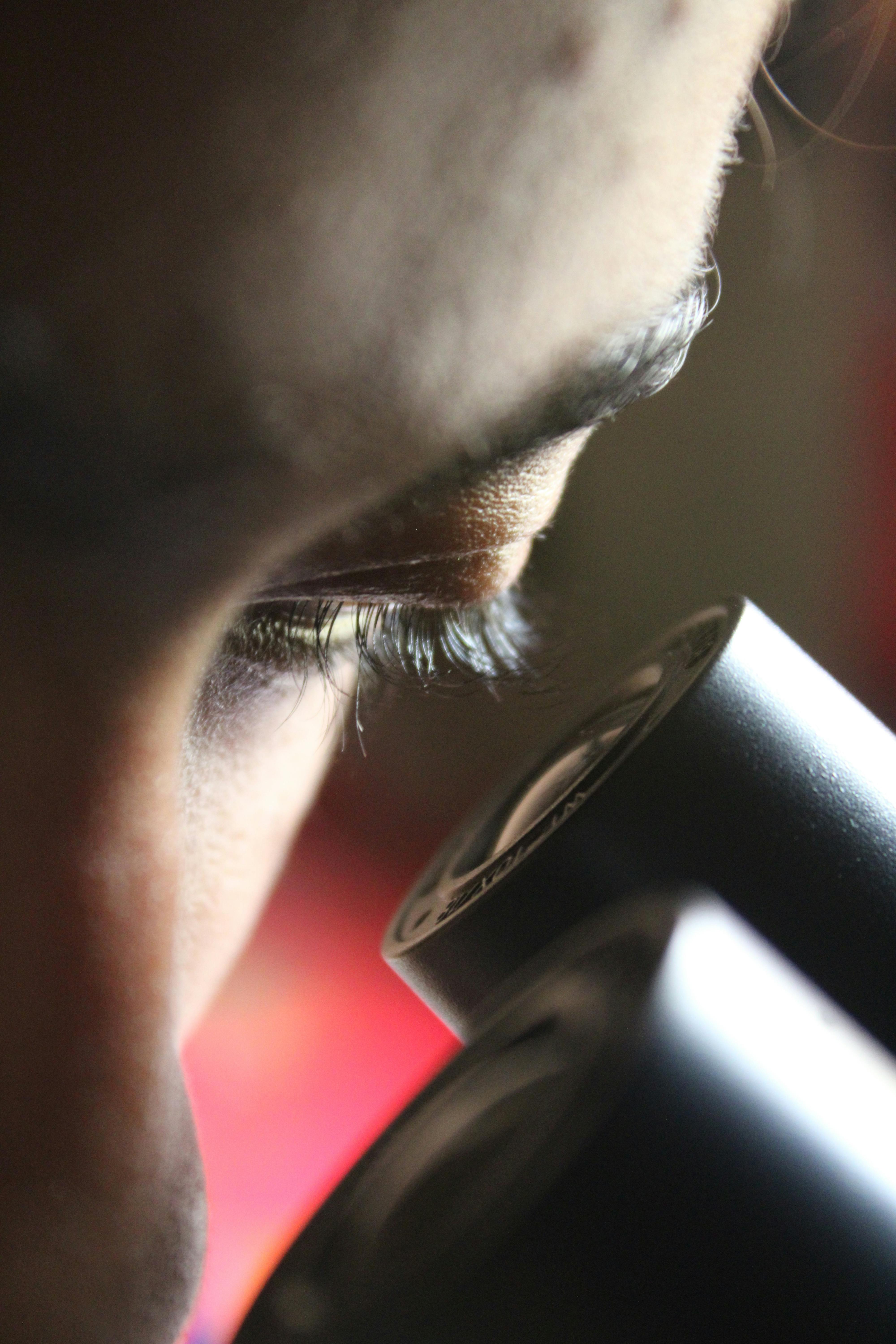 Free Intense focus of a scientist examining a sample through a microscope in a lab setting. Stock Photo