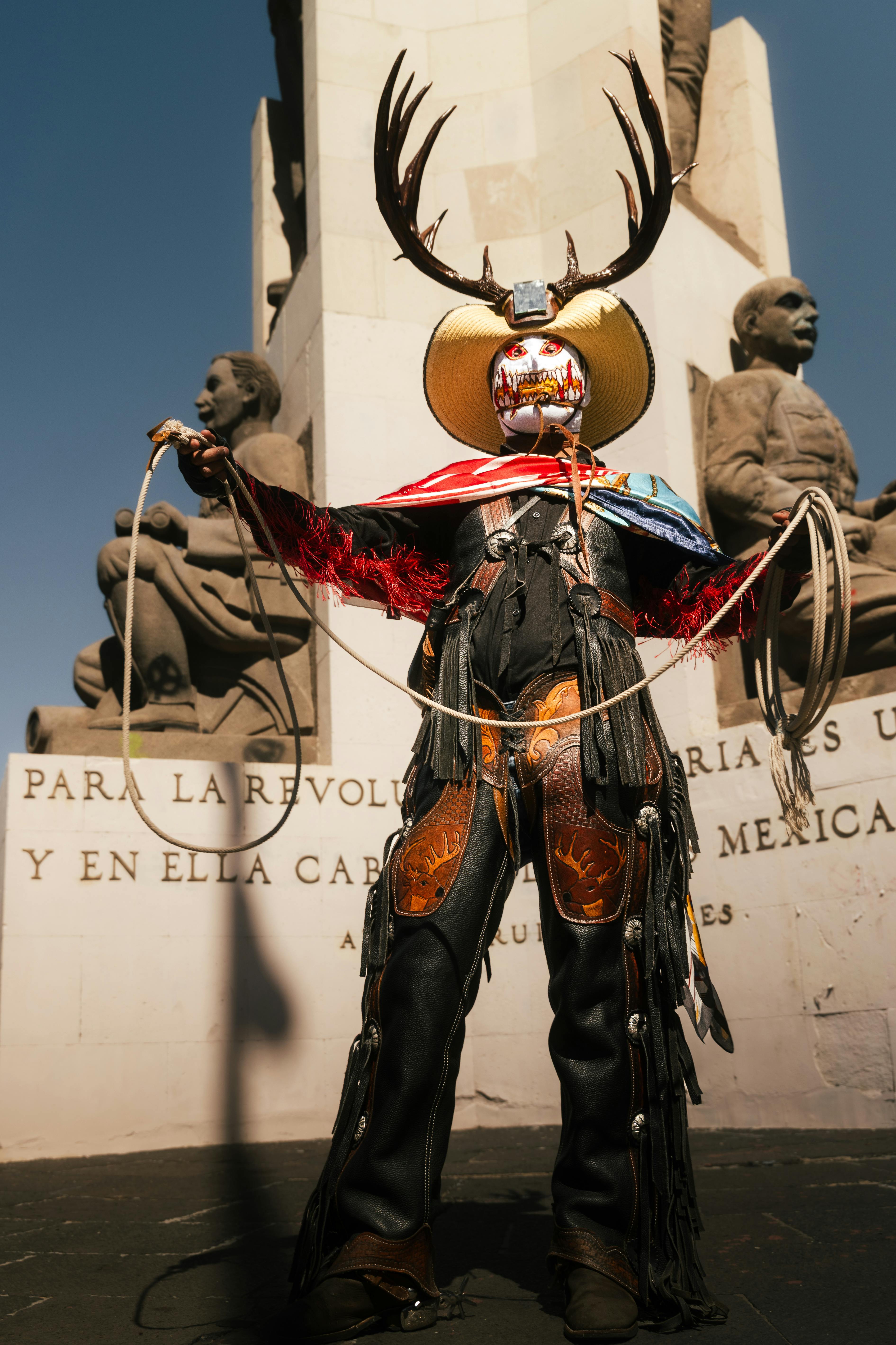 A vibrant display of traditional Mexican attire in front of a historical monument in Pachuca.
