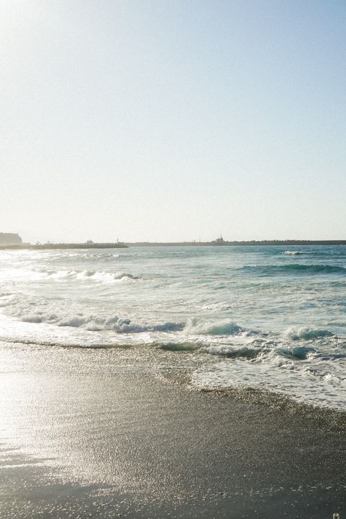 Free Peaceful seaside view with gentle waves under a clear blue sky. Stock Photo