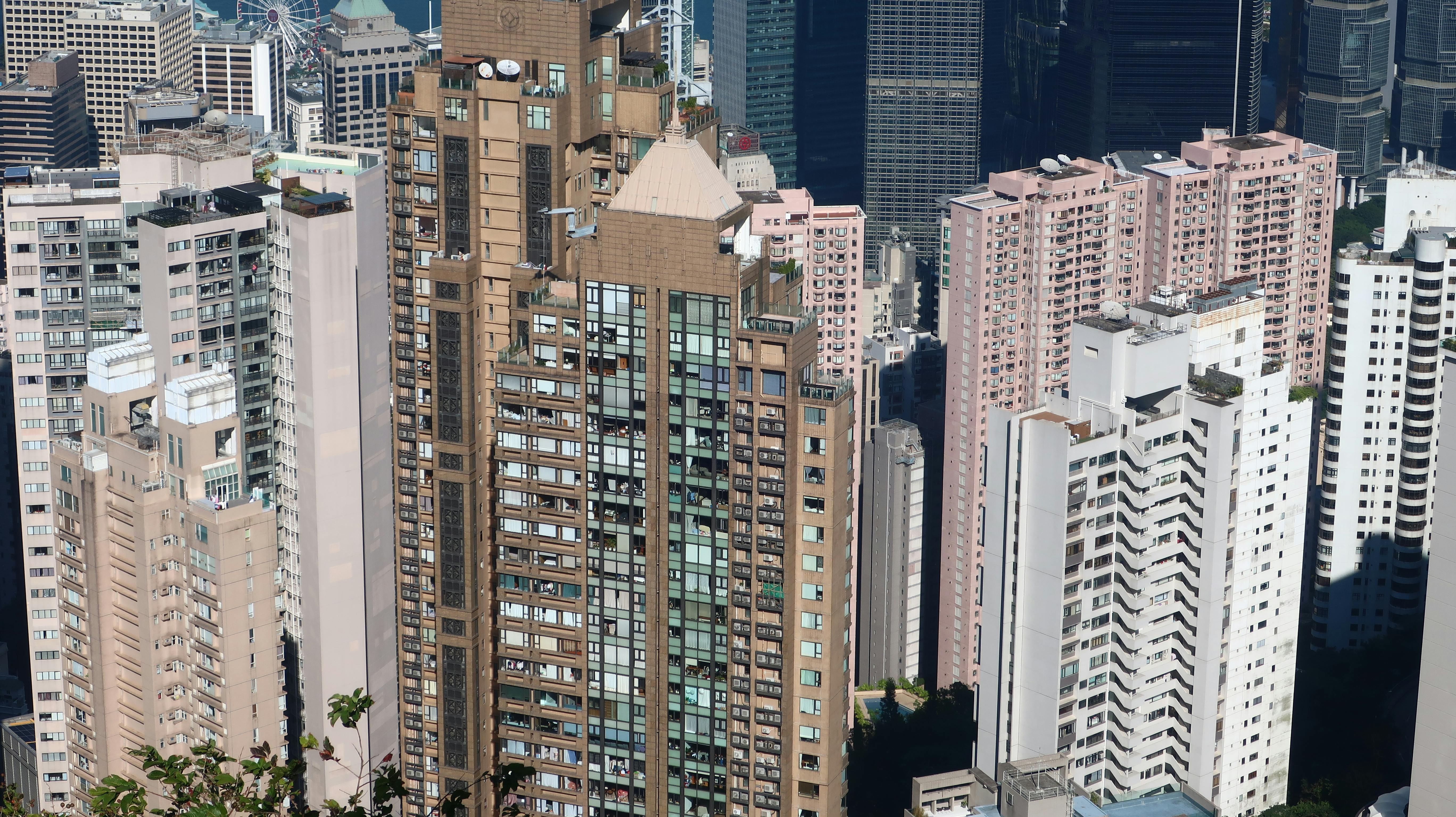 Free Aerial view of high-rise buildings in Hong Kong's skyline on a sunny day. Stock Photo