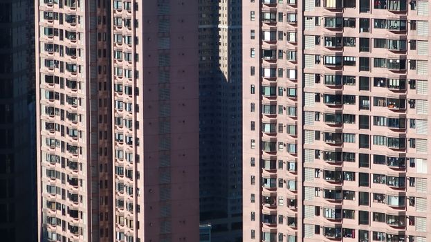 Detailed view of towering residential buildings with balconies on a sunny day.