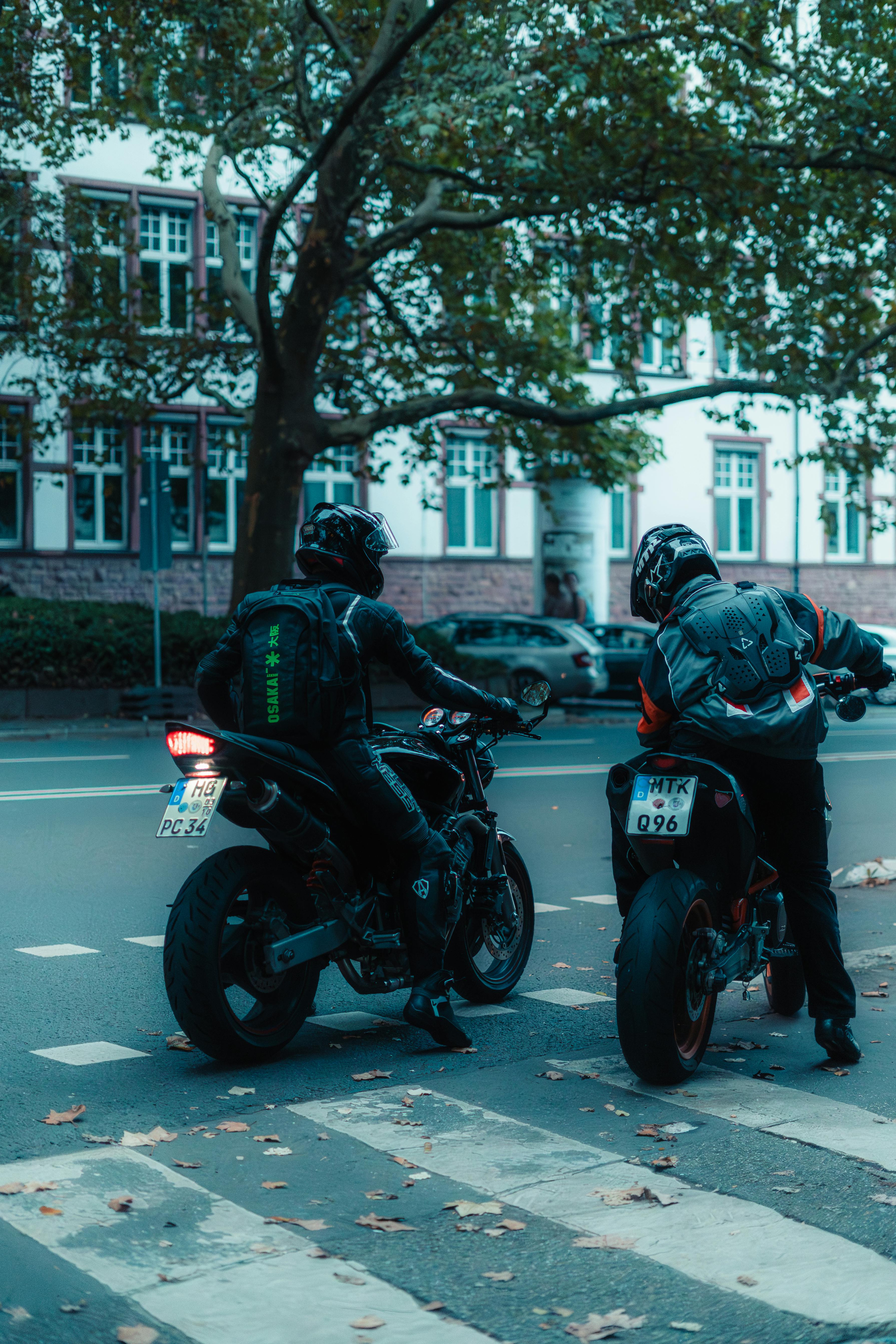 Gratis Due motociclisti in attesa sulle strisce pedonali a Francoforte, in Germania. Foto a disposizione